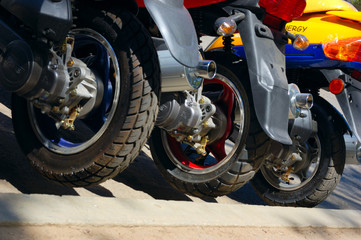 closeup of row of back scooter wheels