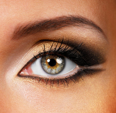 Beautiful shape of female eye with golden-brown cosmetic make-up