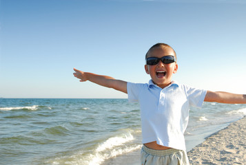 Happy little boy playing  on the beach.
