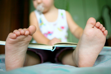 An image of a baby girl reading a book