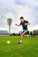 young guy playing football on stadium