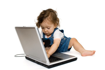 Little girl sitting on laptop,with cd in her hand, isolated
