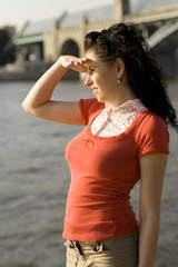 Attractive young woman looking at river water