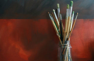 A pot of artists paint brushes in a glass jar
