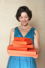 Beautiful woman in blue fashion dress holding a stack of red