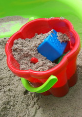 Beach bucket with sand inside.