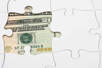 Puzzle with money under it. understanding finances