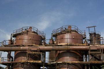 Industrial machinery sits idle against a brilliant blue sky.