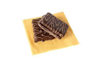 Two chocolate pastry lying on yellow paper napkin