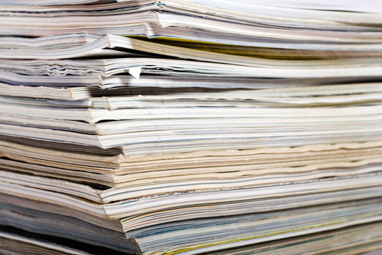 Stack of newspaper on neutral background close up