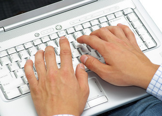 male hands typing on a laptop