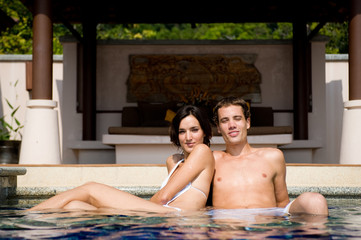 A young couple in swimming pool getting some sun