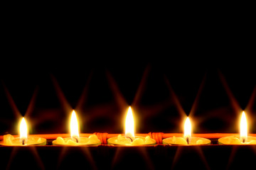 row of candles on black background - 9189541