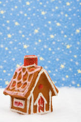 Gingerbread house on snow with star background