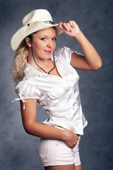 Fototapeta premium cowgirl in a hat on a grey background