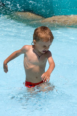 Fototapeta na wymiar a little boy goes waist-deep in water among sparks