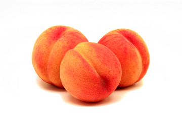 Three fresh peaches on a white background