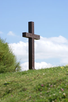 Wood cross at the top of the green hill