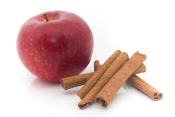 red apple and cinnamon on white background
