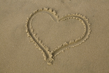 Image of a heart drawn in the sand, with a blankcenter.