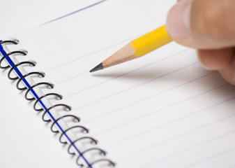 Note pad with pencil being held by a person