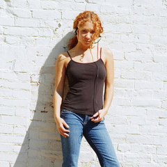 Attractive urban girl against white brick wall.