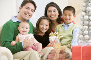 Family With New Born,Sitting On Sofa,Holding Christmas Gift