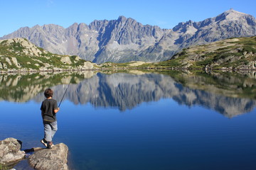 jeune gar&ccedil;on p&ecirc;chant dans un lac de montagne