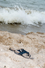 A pair of sandals on the beach, signifying a relaxing vacation