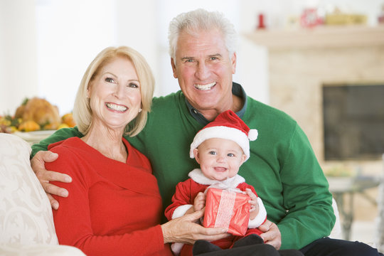 Grandparents With Baby In Santa Outfit