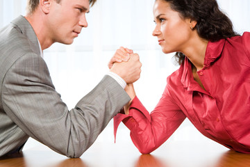 Man and woman in arm wrestling gesture