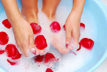 Fototapeta premium woman legs in relaxing spume with rose petal
