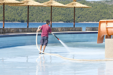 a man washing swimming pool