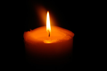 Close up of a solitary candle burning, symbol of peace.