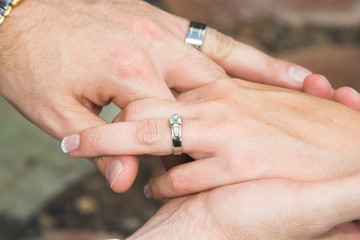 Groom holding his new bride's hand gently