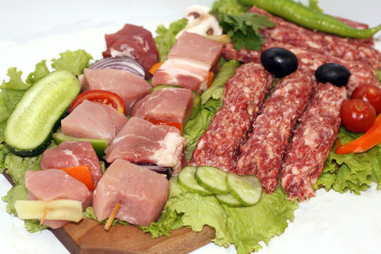 raw meat on wooden plate decorated with vegetables