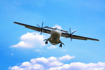 propeller airplane landing in cloudy sky