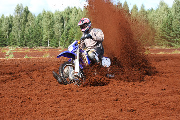 Off-road motorbike extreme cornering in dirt.