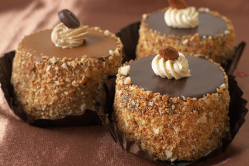 Three miniature chocolate meringue cakes with cream