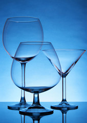 Still-life with empty glasses over blue background