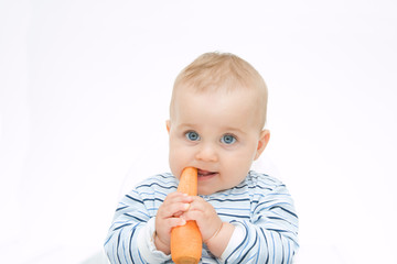 little, cute baby boy eating fresh carrot, on white