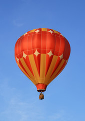 Naklejka premium Red and orange hot air balloon in the blue sky.