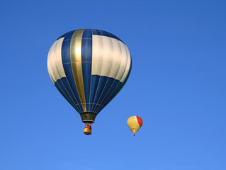 Two beautiful hot air balloons in the blue sky.