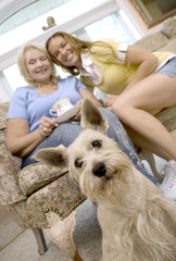 mother and daughter enjoying coffee with their dog