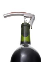 Opening wine bottle with a corkscrew on white background