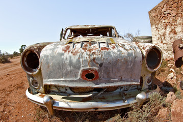 an old car rusts away in the hot australian desert