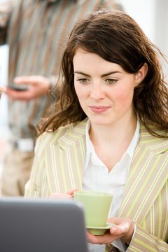Young happy businesswoman working on laptop at office