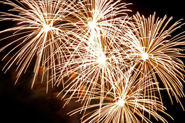 Many golden fireworks bursts at fireworks festival.