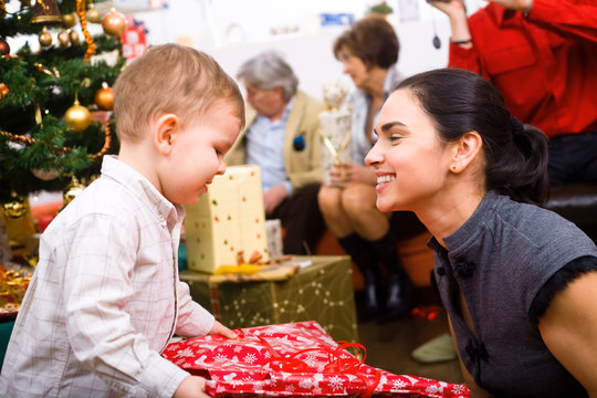 Little boy ( 3 years ) and mother giving Christmas present