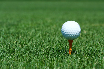 A White golf ball on a orange tee